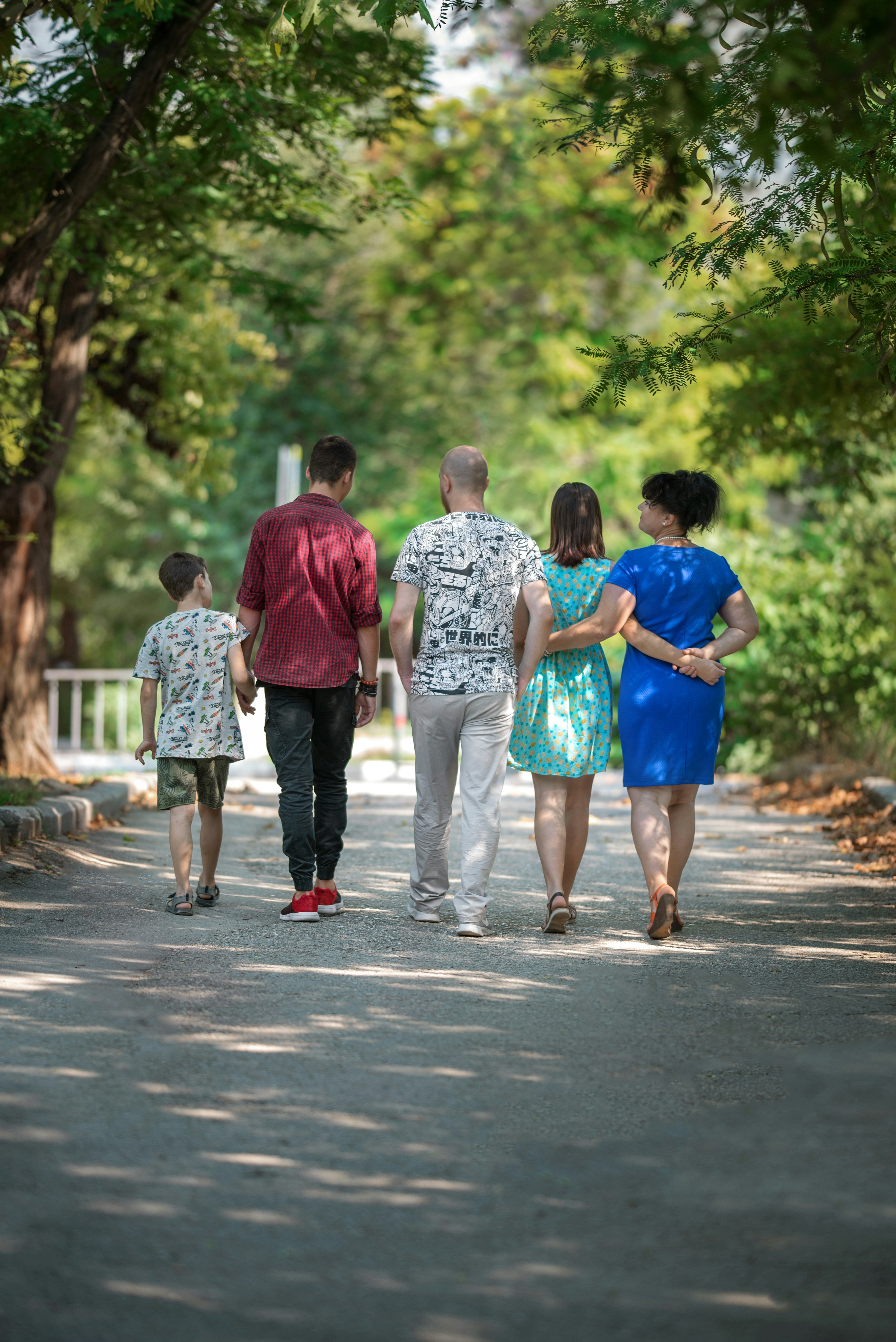 family walking along trees-lined path